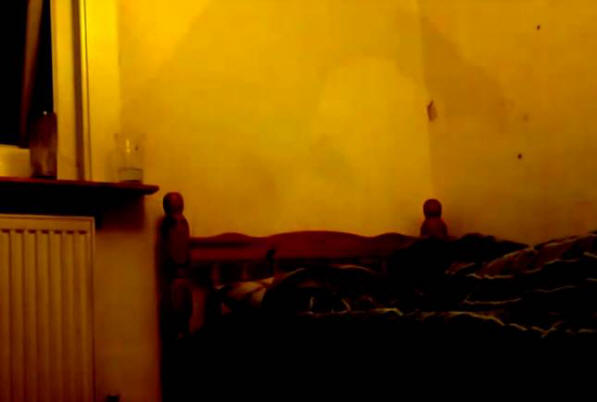 Mies ampui sumuista varjoa sängyn päässä olevalle kameralle.